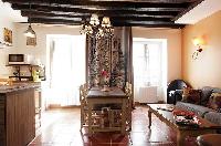 cozy dining area, kitchen and living area with exposed beams in a 2-bedroom Paris luxury apartment