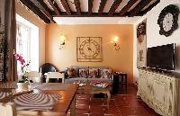 cozy dining area and living area with exposed beams in a 2-bedroom Paris luxury apartment