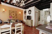 cozy dining area, living area and kitchen with exposed beams in a 2-bedroom Paris luxury apartment