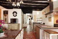 cozy dining area, hallway and kitchen with exposed beams in a 2-bedroom Paris luxury apartment