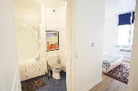 cozy bedroom and en suite bathroom in a 1-bedroom Paris luxury apartment