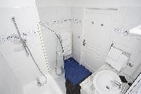 en-suite bathroom with a toilet, a sink, built-in mini cabinet, a mirror, and a bathtub with a detac
