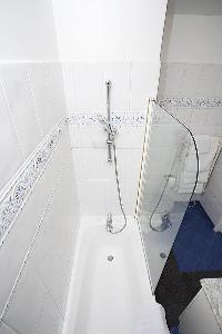 en-suite bathroom with a toilet, a sink, built-in mini cabinet, a mirror, and a bathtub with a detac
