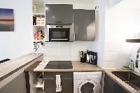 monochromatic and space-efficient kitchen in a 1-bedroom Paris luxury apartment