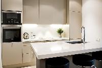 modern yet classy kitchen with breakfast bar and stools in Paris luxury apartment