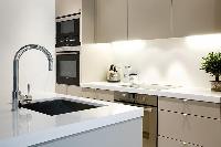 modern yet classy kitchen with breakfast bar and stools in Paris luxury apartment