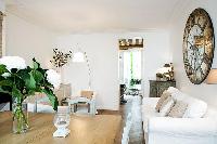 classy living area with two armchairs, a table, a television, and a fireplace in Paris luxury apartm