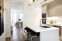 modern yet classy kitchen with breakfast bar and stools in Paris luxury apartment