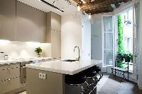 modern yet classy kitchen with breakfast bar and stools in Paris luxury apartment