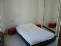 minimalist bedroom with queen-size bed in a 3-bedroom Paris luxury apartment
