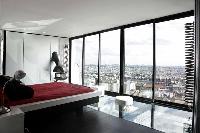 minimalist bedroom with queen-size bed and skyline view of Paris
