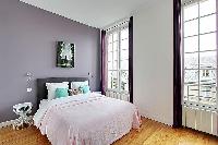 spacious first bedroom with a queen-size bed in a 3-bedroom Paris luxury apartment