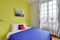 bedroom in yellow and white hues in a Paris luxury apartment
