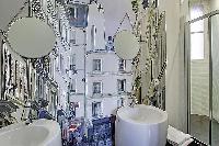 stylish bathroom with a toilet, sink, shower, and a bathtub in a 3-bedroom Paris luxury apartment