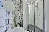 stylish bathroom with a toilet, sink, shower, and a bathtub in a 3-bedroom Paris luxury apartment