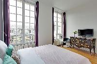 spacious bedroom with a queen-size bed in a 3-bedroom Paris luxury apartment