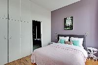 spacious bedroom with a queen-size bed in a 3-bedroom Paris luxury apartment