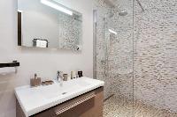 an en-suite bathroom with a sink, toilet, and shower area in a 4-bedroom Paris luxury apartment