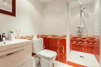 an en-suite bathroom with a sink, toilet, and shower  in a 4-bedroom Paris luxury apartment