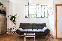 living area with a double sofa bed and potted plants  in a 1-bedroom Paris luxury apartment
