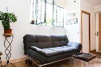 living area with a double sofa bed and potted plants  in a 1-bedroom Paris luxury apartment