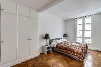 bedroom furnished with queen-size bed,colorful bedspreads, a large dressing area, built-in closets, 