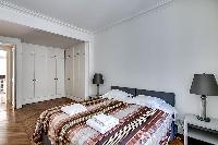 bedroom furnished with queen-size bed,colorful bedspreads, a large dressing area, built-in closets, 