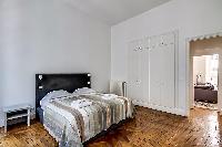 bedroom furnished with queen-size bed,colorful bedspreads, a large dressing area, built-in closets, 