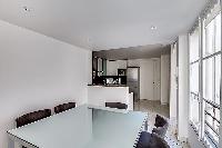modern dining area with a dining table set for six in a 3-bedroom Paris luxury apartment