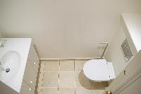 white toilet and sink in a 3-bedroom Paris luxury apartment