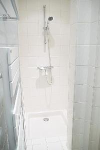 immaculate white en-suite bathrooms with detachable shower head in a 3-bedroom Paris luxury apartmen