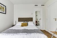 cozy bedroom fully-furnished with a small desk, automated blackout shutters, double-glazed windows, 