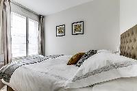 cozy bedroom fully-furnished with a small desk, automated blackout shutters, double-glazed windows, 