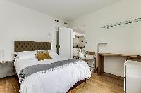 cozy bedroom fully-furnished with a small desk, automated blackout shutters, double-glazed windows, 