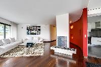 spacious living area furnished with two white couches, an elegant fuzzy rug, and a center table, and