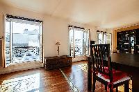 dining area with a dark walnut table and four chairs in a 1-bedroom Paris luxury apartment