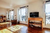 spacious living area with large shelves filled with books, a wooden center table, and a double sofa 