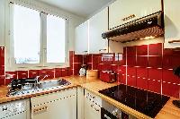 warm and inviting red kitchen in a 1-bedroom Paris luxury apartment