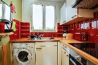 warm and inviting kitchen with a combo washer and dryer in a 1-bedroom Paris luxury apartment