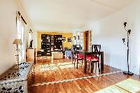 spacious living area with large shelves filled with books, a wooden center table, and a double sofa 