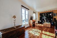 spacious living area with large shelves filled with books, a wooden center table, and a double sofa 