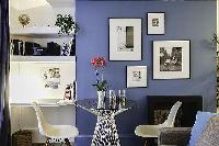 mini dining area with round glass dining table and white chairs in a 1-bedroom Paris luxury apartmen