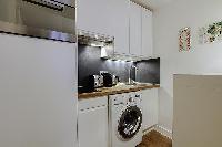 well-equipped kitchen with combo washer and dryer in a 1-bedroom Paris luxury apartment