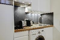 well-equipped kitchen with combo washer and dryer in a 1-bedroom Paris luxury apartment