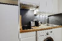 well-equipped kitchen with combo washer and dryer in a 1-bedroom Paris luxury apartment