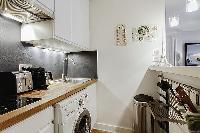 well-equipped kitchen with combo washer and dryer in a 1-bedroom Paris luxury apartment