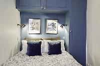 bedroom with built-in closets and a double bed in a 1-bedroom Paris luxury apartment