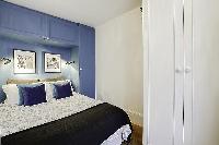 bedroom with built-in closets and a double bed in a 1-bedroom Paris luxury apartment