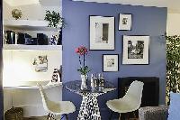 mini dining area with round glass dining table and white chairs in a 1-bedroom Paris luxury apartmen