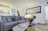 comfortable grey sofa bed and center table in a 1-bedroom Paris luxury apartment